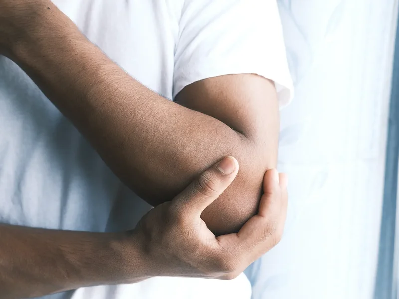 Physical therapist assessing a patient's elbow and wrist movement and mobility