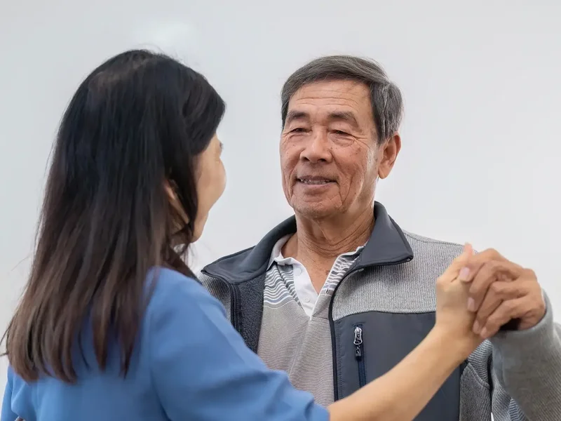 Physical therapist assessing a patient's balance and movement for Parkinson's