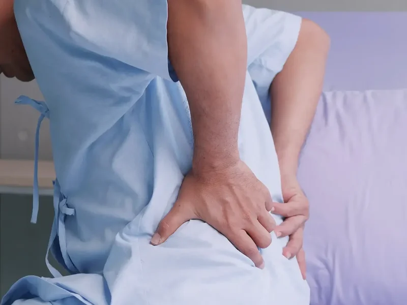 Physical therapist assessing a patient's low back and leg movement for sciatica